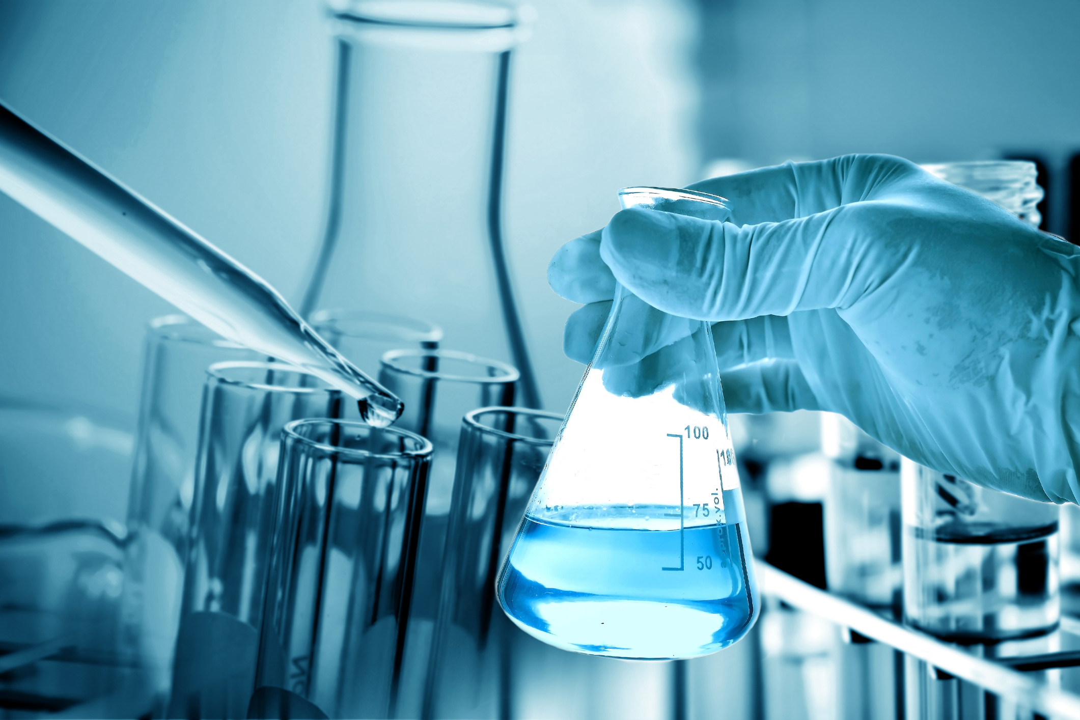 Flask in scientist hand with laboratory background